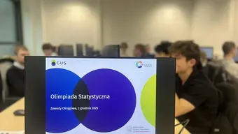 Zdjęcie monitora z nazwą olimpiady w tle uczniowie