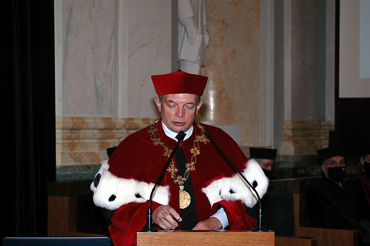 Przemówienie prorektora AGH ubranego w czerwoną długą togę z kołnierzem z gronostajów i czerwone nakrycie głowy oraz łańcuch z insigniami