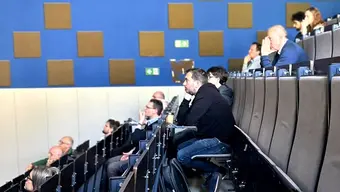 Grupa osób siedzaca na sali wykładowej