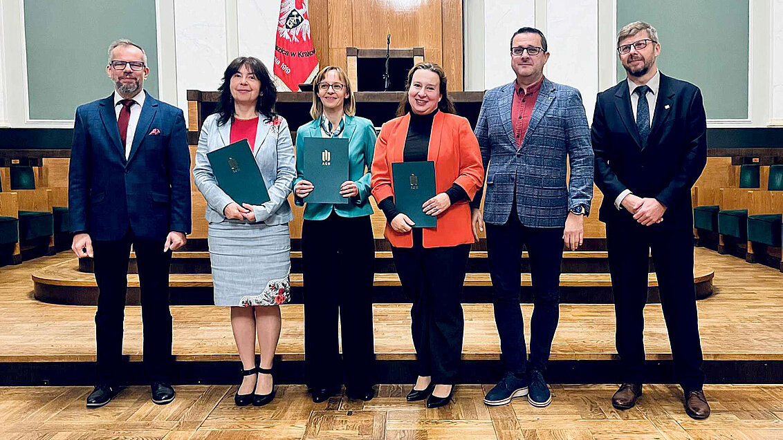 grupa osób z dyplomami w auli