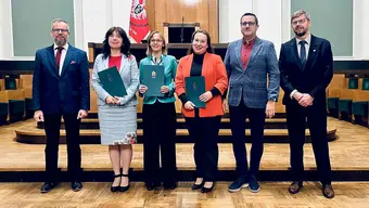 grupa osób z dyplomami w auli