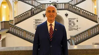 Mężczyzna w garniiturze na tle wnetrza auli