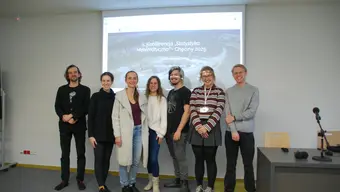 Grupa ludzi na tle projektora tablicy podczas konferencji