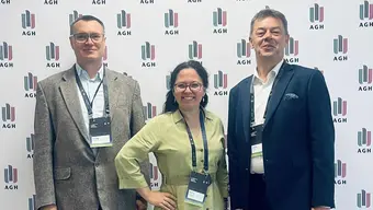 dwóch mężczyzn i kobieta na sciance z logotypem AGH