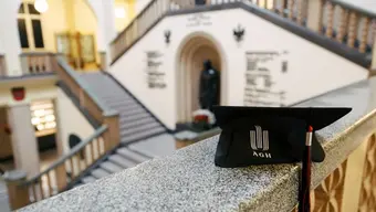 Biret w tle widok na hol w budynku AO AGH