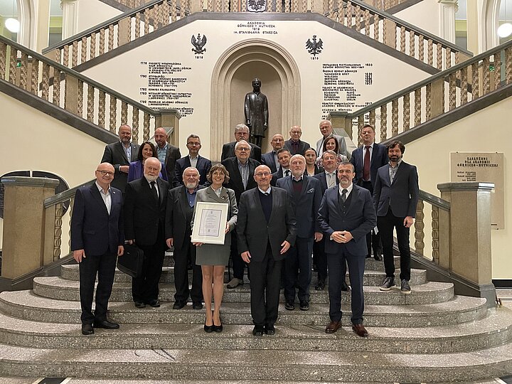 Grupa ludzi stojąca na schodach.