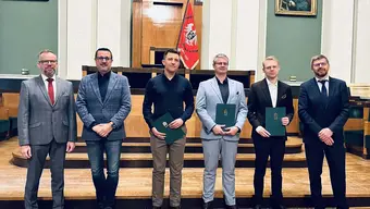 Grupa mężczyzn z dyplomami w ręku