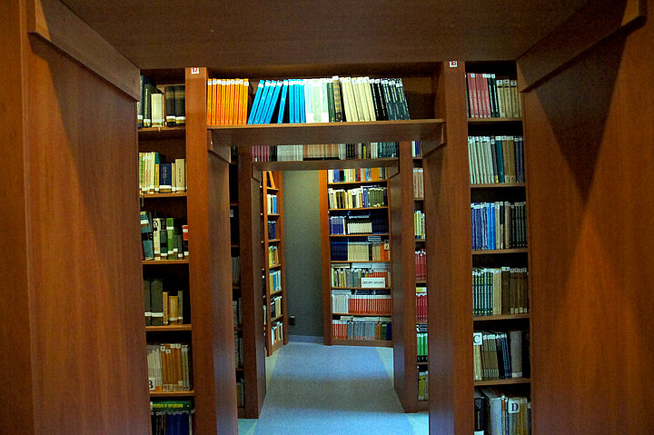 Wnetrze biblioteki, ksiązki na regałach.