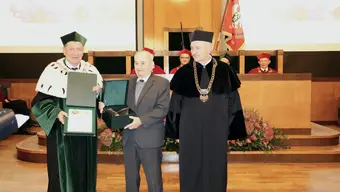 Trzy osoby w odświętnie ubrane w auli AGH