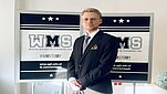 MĘŻCZYNA NA TLE LOGOTYPU WMS